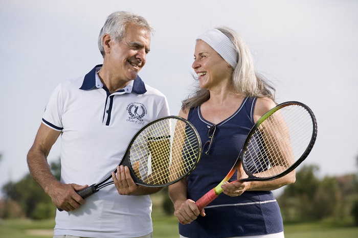 happy senior couple playing tennis