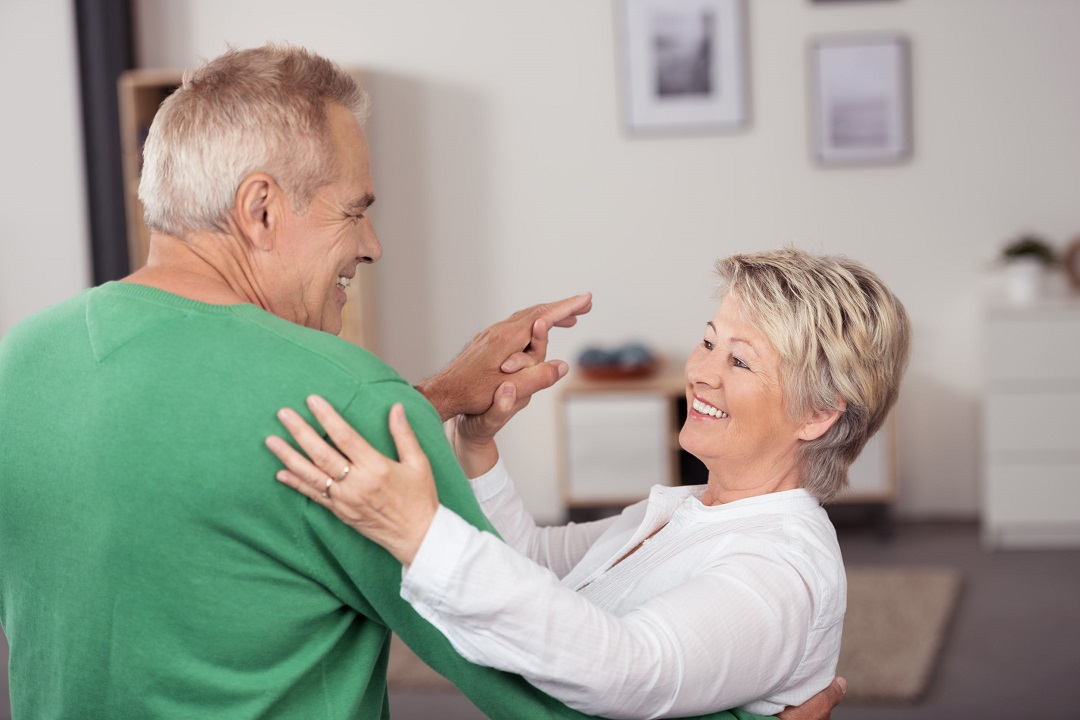 Active Middle Aged Couple Dancing So Sweet While Smiling Each Other at the Living Room Inside their House