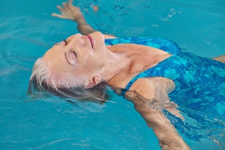 33758572 - happy senior woman relaxing in swimming pool with water yoga