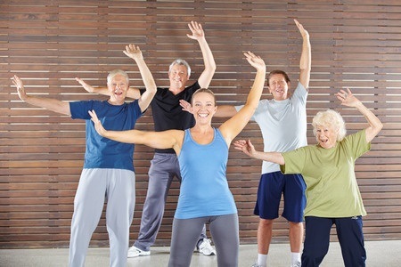 36678370 - group of happy seniors dancing and exercising in gym class