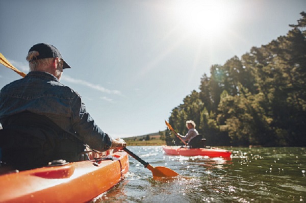 Image of senior couple canoeing in the lake on a sunny day. Kayakers in the lake paddling._preview