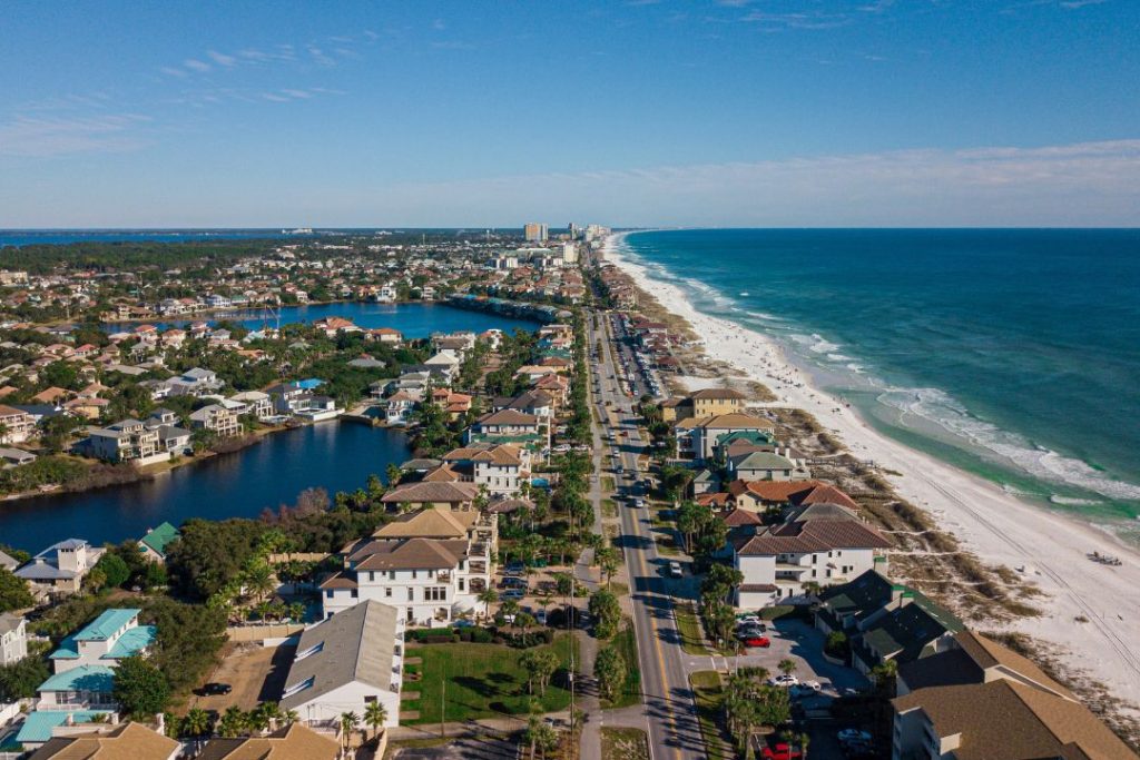 Aerial View of Houses Near A Beach Under Blue Sky