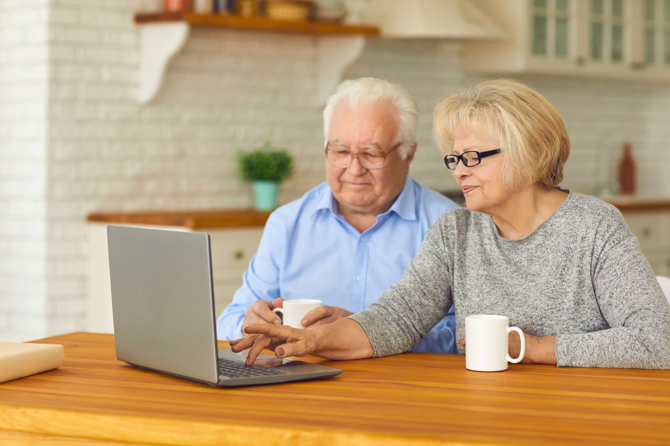 Couple using computer while drinking coffee