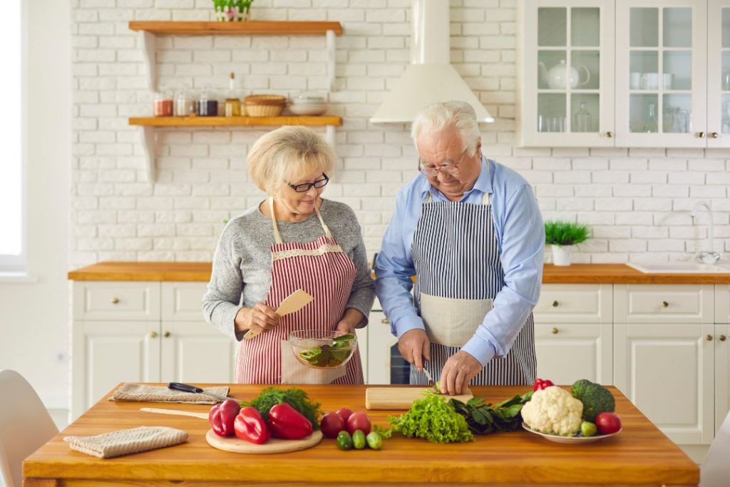 Senior couple cutting vegetables cooking healthy foods