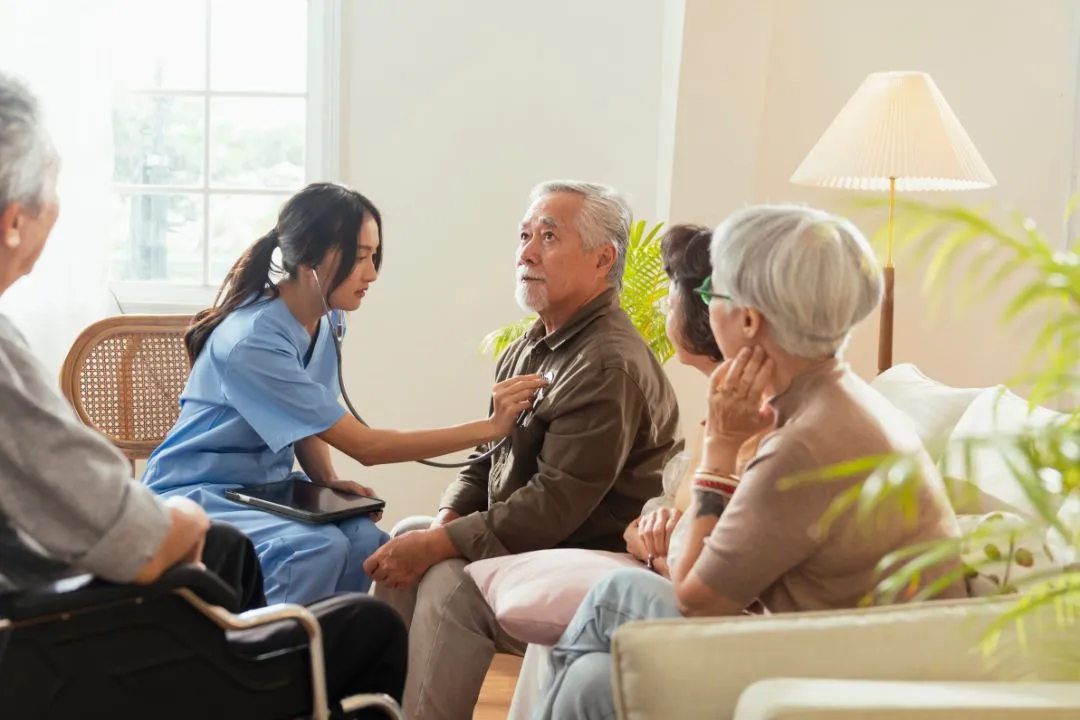  senior Asian woman receives medical advice from her doctor at home, highlighting personalized healthcare and comfort.