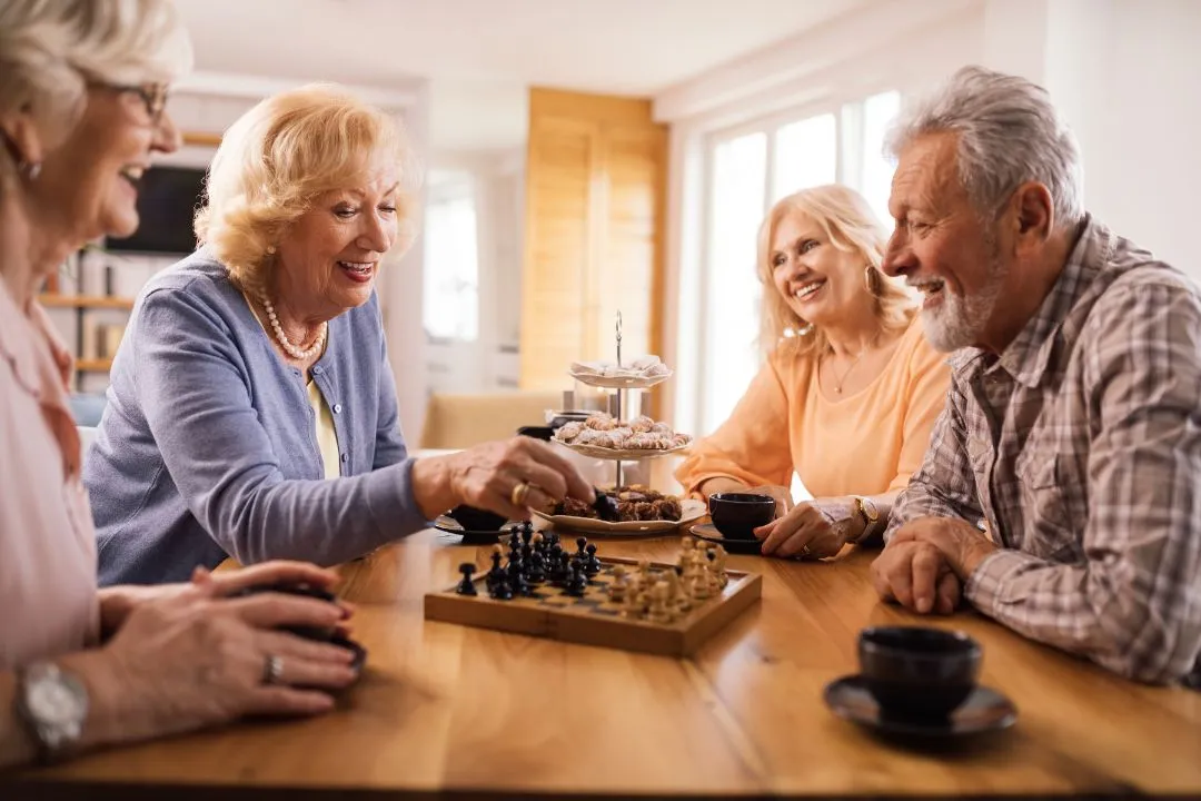 Senior adults engaged in a chess game at home, showcasing concentration and camaraderie in a cozy setting.