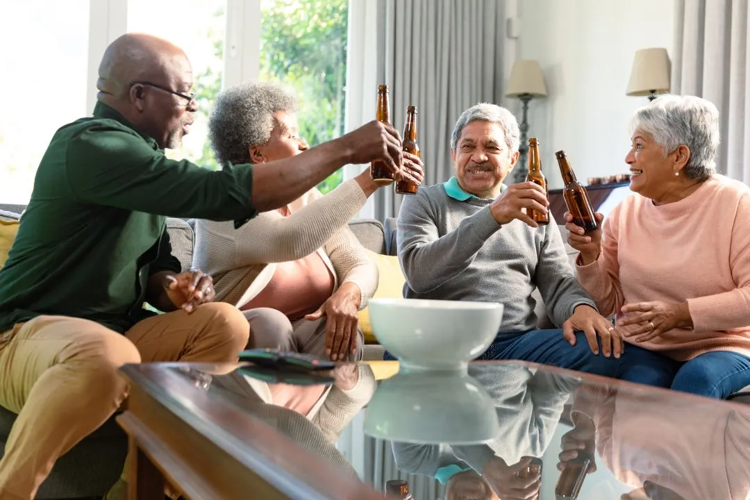 A diverse group of friends joyfully toasting with beer glasses, celebrating together in a lively atmosphere.