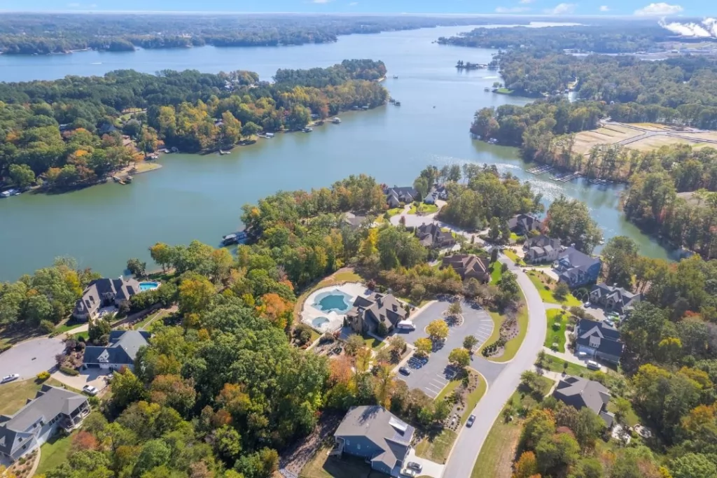 Scenic aerial shot of a lake in autumn, featuring homes nestled among the brilliant fall colors.