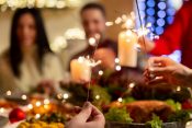 A festive gathering with people joyfully holding sparklers during a Christmas dinner celebration in December.