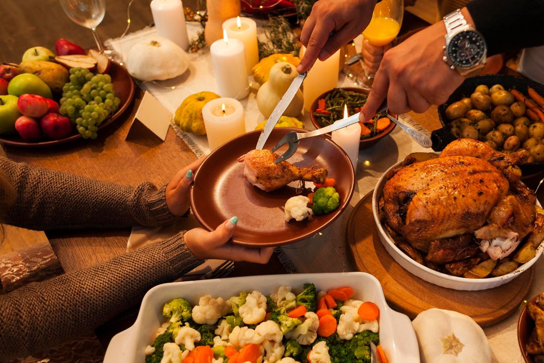 A festive dining table set with a golden turkey, colorful vegetables, and an array of delicious side dishes for celebration.