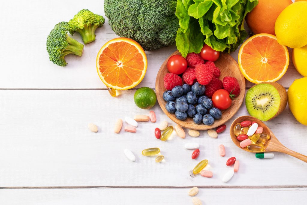 An array of fresh fruits and vegetables on a wooden table, showcasing their rich vitamins and promoting healthy eating.