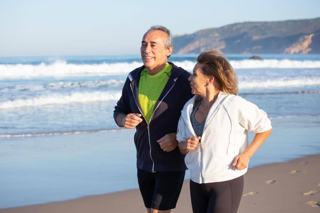 Couple of seniors jogging at the beach