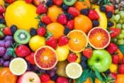 Colorful assortment of water-rich fruits including watermelon, strawberries, oranges, kiwi, lemons, grapes, and blackberries — perfect for staying hydrated in summer.