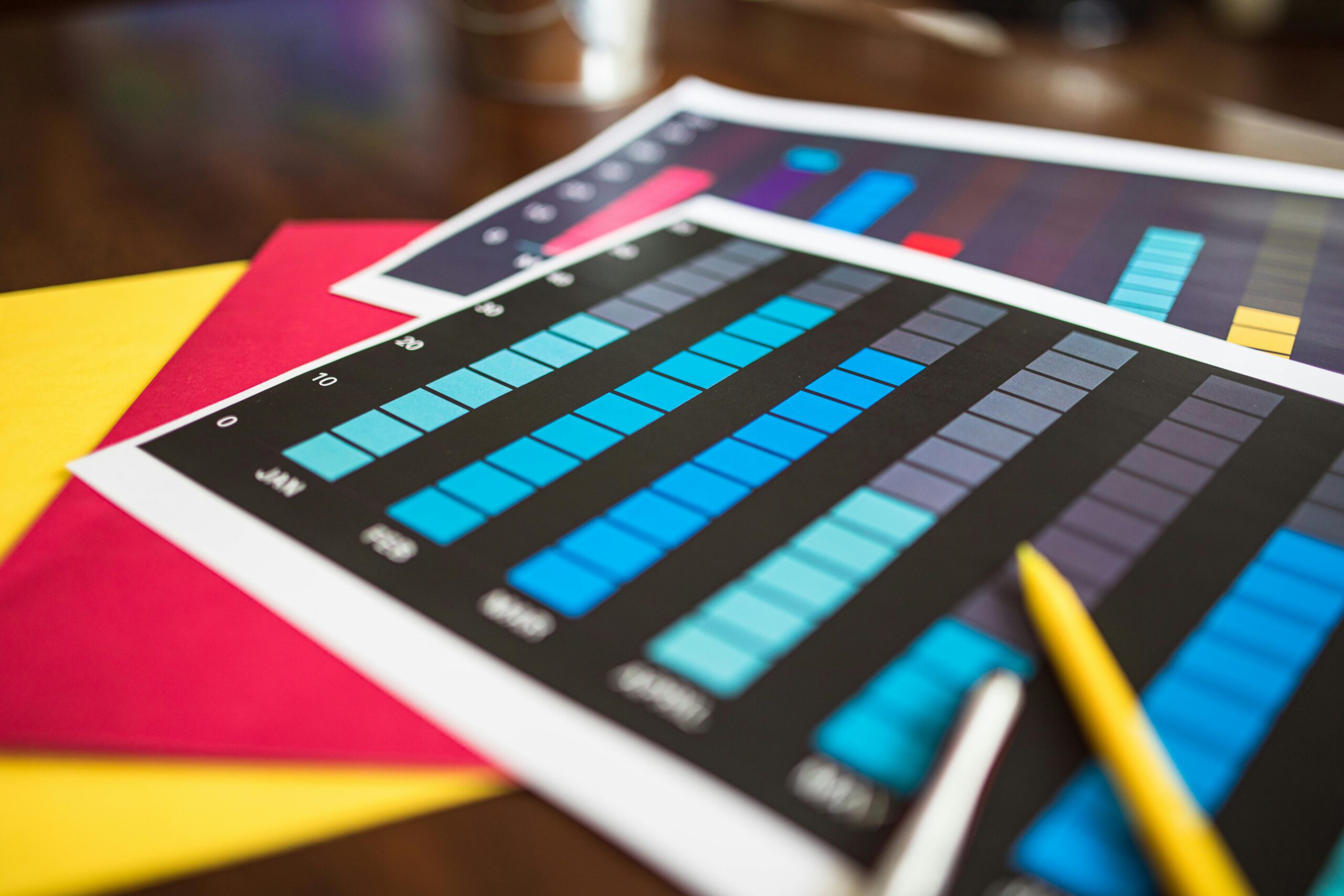 Calculator, colored pencils, notebooks, and charts surrounding a paper with a blue bar graph and the word "Retirement" written above it.