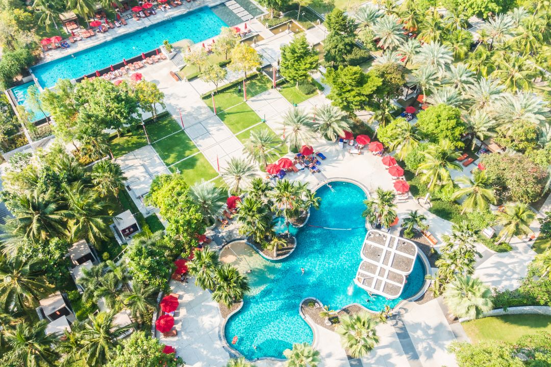 Panoramic view of a beautiful 55+ community with clubhouse, swimming pool, tennis courts, and walking paths, bright sunny day