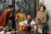 Group of joyful retirees celebrating together outdoors with music, food, and decorations, representing community living, warm colors