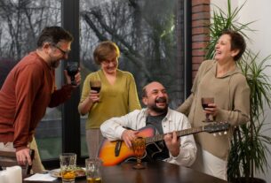 Group of joyful retirees celebrating together outdoors with music, food, and decorations, representing community living, warm colors