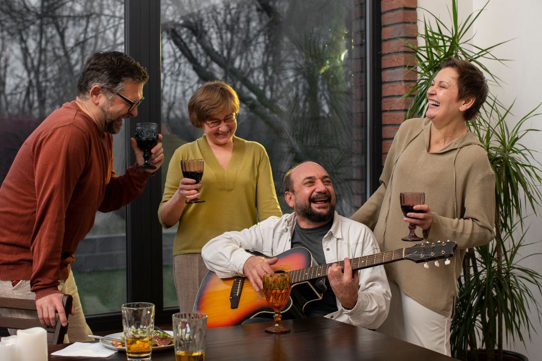 Group of joyful retirees celebrating together outdoors with music, food, and decorations, representing community living, warm colors